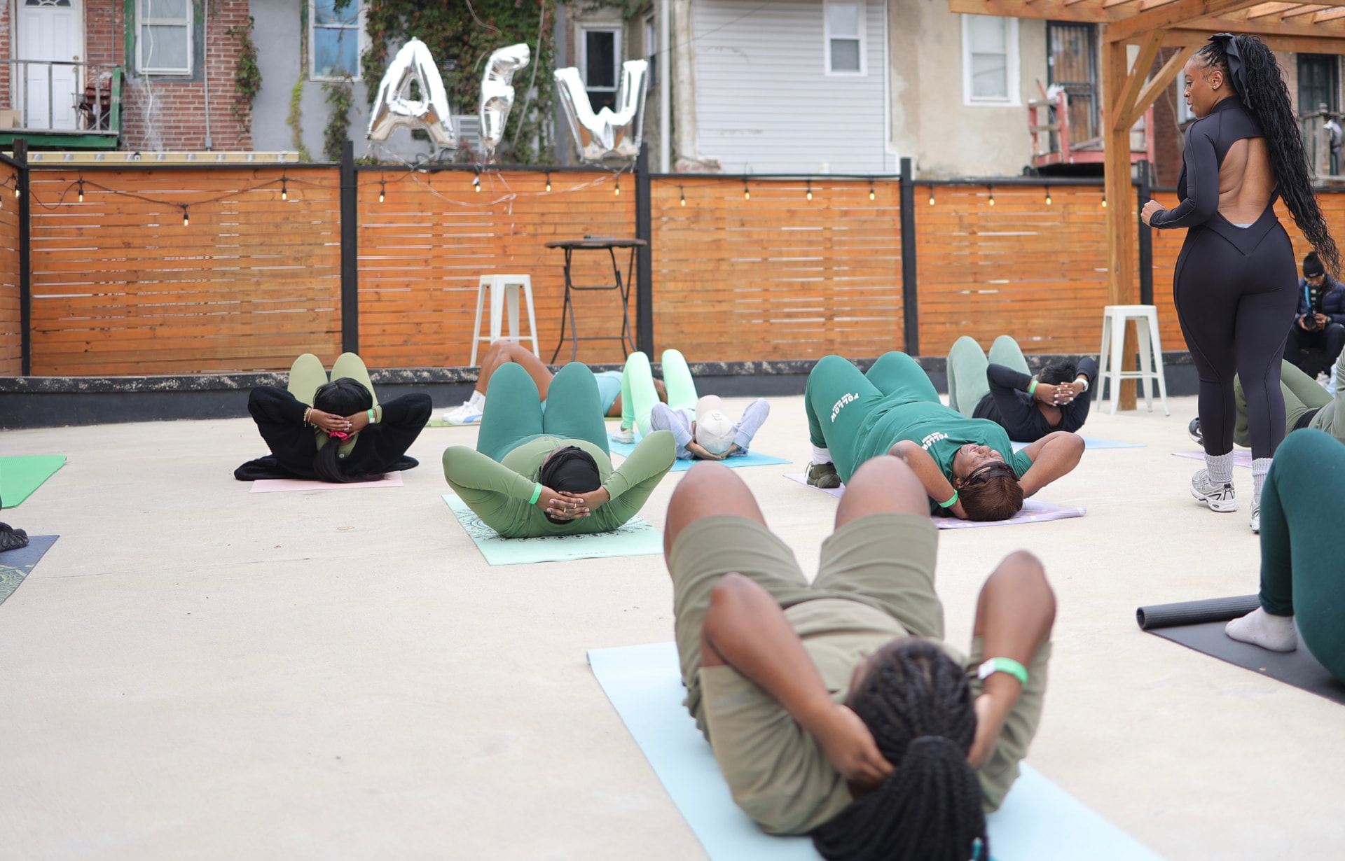 Group workout beneath the AyrFitWomen balloons at the 2025 experience
